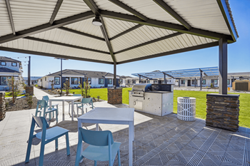 A patio with a table and chairs under a canopy.